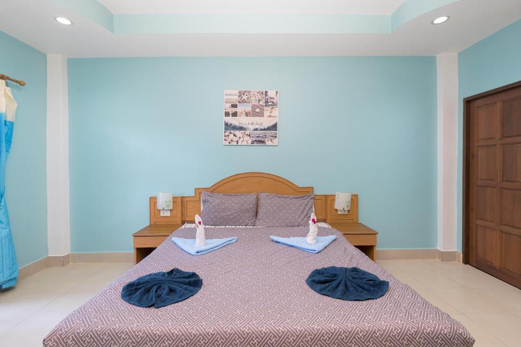 a bedroom with a bed with two towels on it at Grand View in Patong Beach