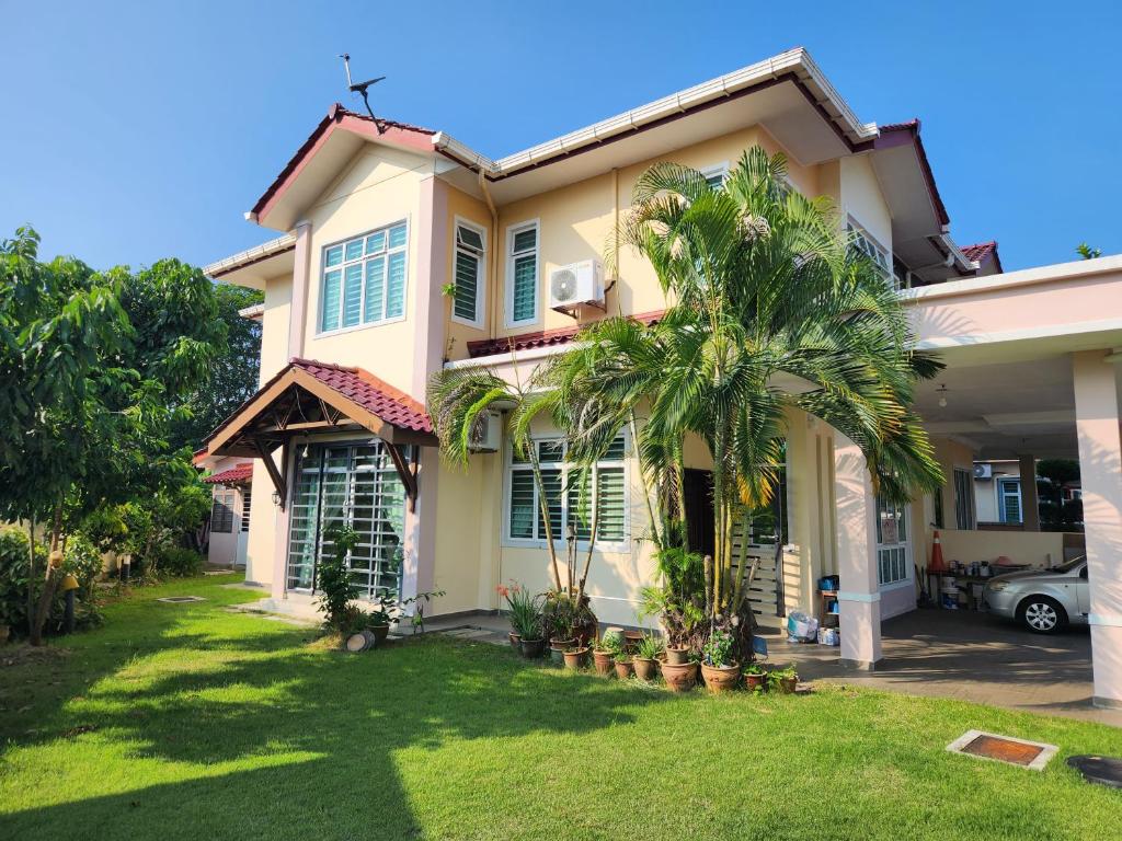 una casa con una palma di fronte di Wakaf Bharu Garden Stay Semi-D By UJ a Kota Bharu