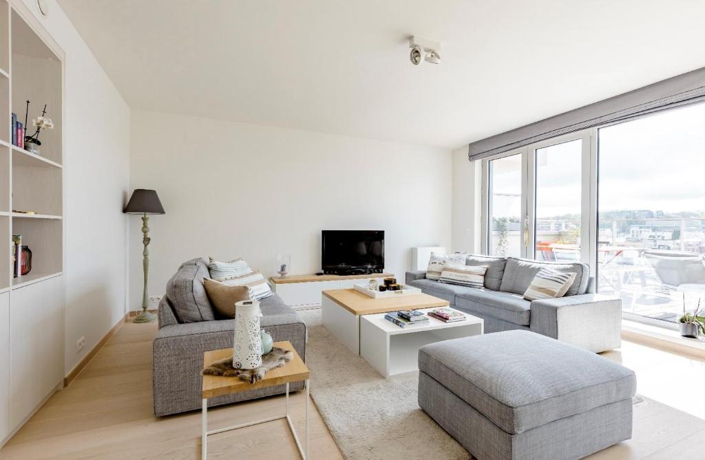 a living room with a couch and a table at B&B Le Murmure de l'eau - Chambre d'hôte Urbaine - Namur in Namur