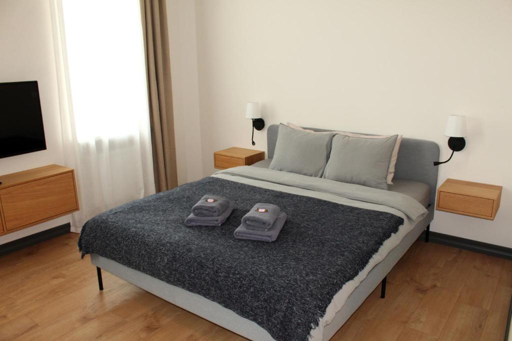 Un dormitorio con una cama con dos controles remotos. en Cēsu apartamenti en Cēsis