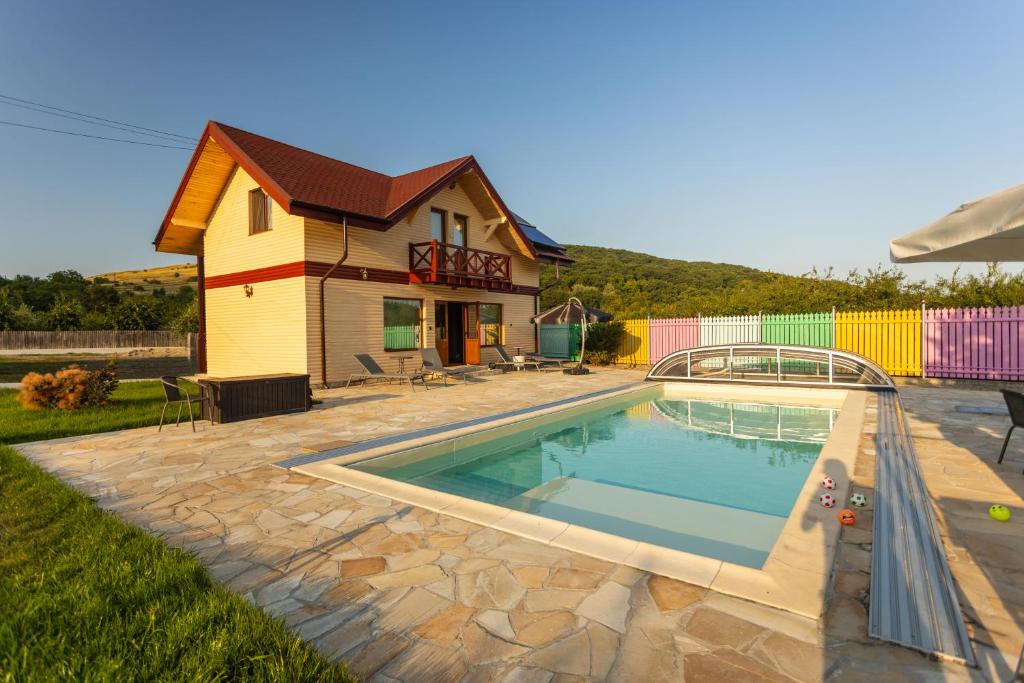 a swimming pool in front of a house at Casa TaMi in Piatra Neamţ