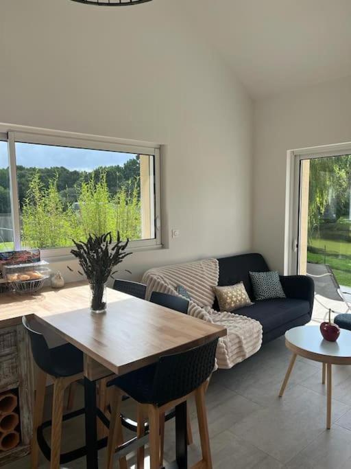 un salon avec une table et un canapé dans l'établissement La petite maison, à Plélan-le-Petit