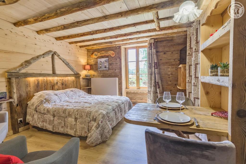 1 dormitorio con 1 cama, mesa y sillas en LE SABOT DE VENUS, en Termignon