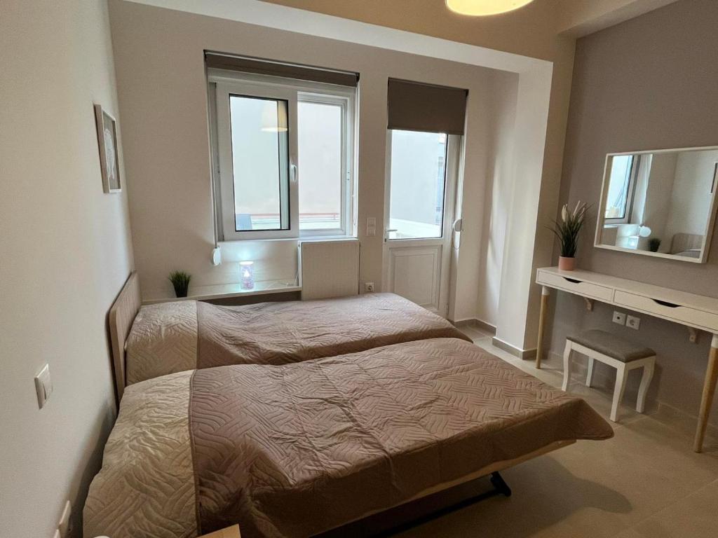 a bedroom with two beds and a desk and window at Irida Apartment Nafplio in Nafplio