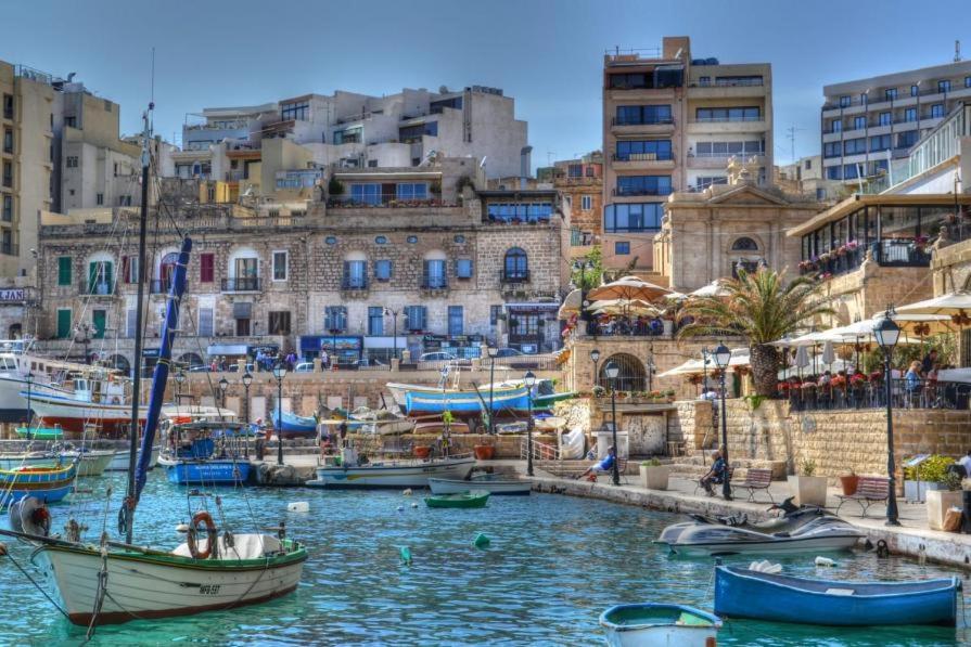 a group of boats in a harbor with buildings at Luxury home with sea views in St. Julianʼs