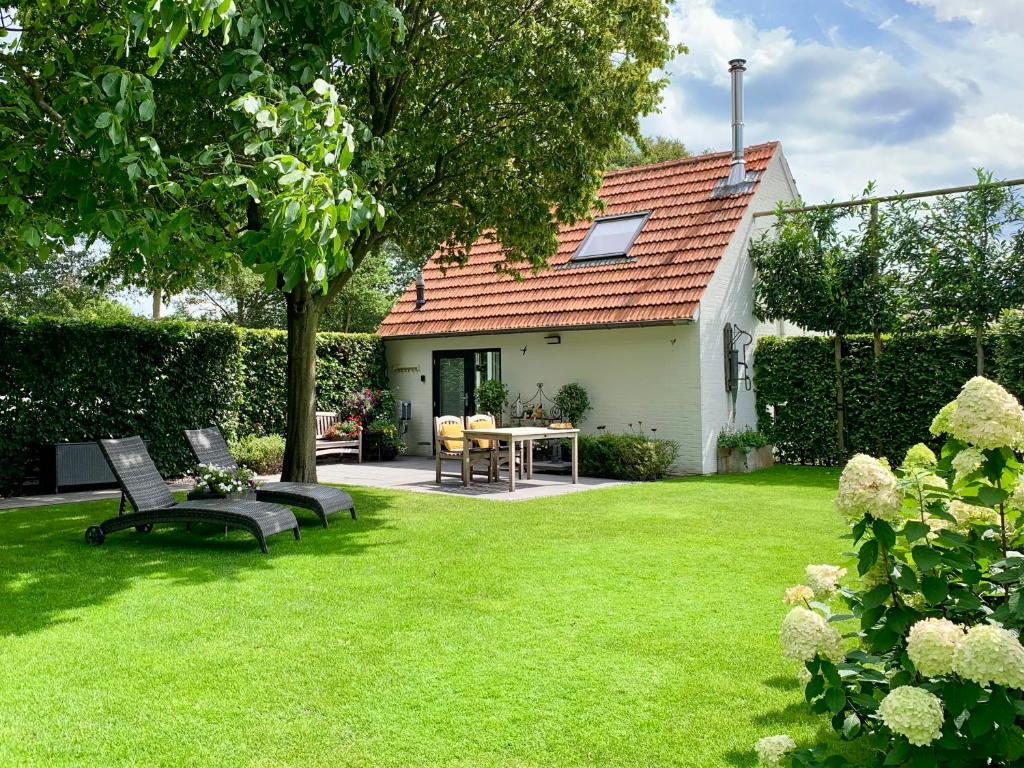 een tuin met twee banken en een tafel en een huis bij Bed & breakfast Heitse in Heythuysen
