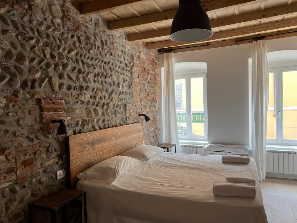Ce lit se trouve dans une chambre dotée d'un mur en briques. dans l'établissement Borgovivobg il tuo rifugio in centro città, à Bergame