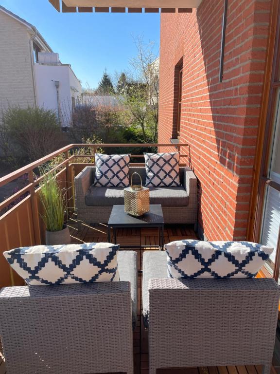 eine Terrasse mit 2 Sofas und einem Tisch auf dem Balkon in der Unterkunft HAPPY PLACE mit Sonnen-Balkon und Stellplatz nur 400 m zum Strand in Scharbeutz