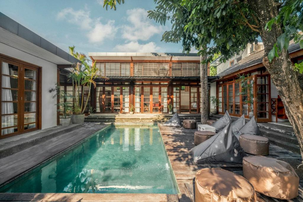 an exterior view of a house with a swimming pool at Batu Belig Living Managed by CPM Bali in Seminyak