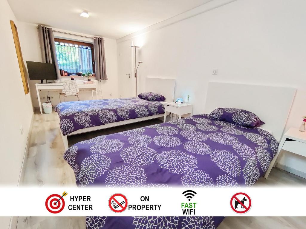 um quarto com 2 camas com edredão roxo em Tranquil City Haven close to Airport & Basel em Saint-Louis