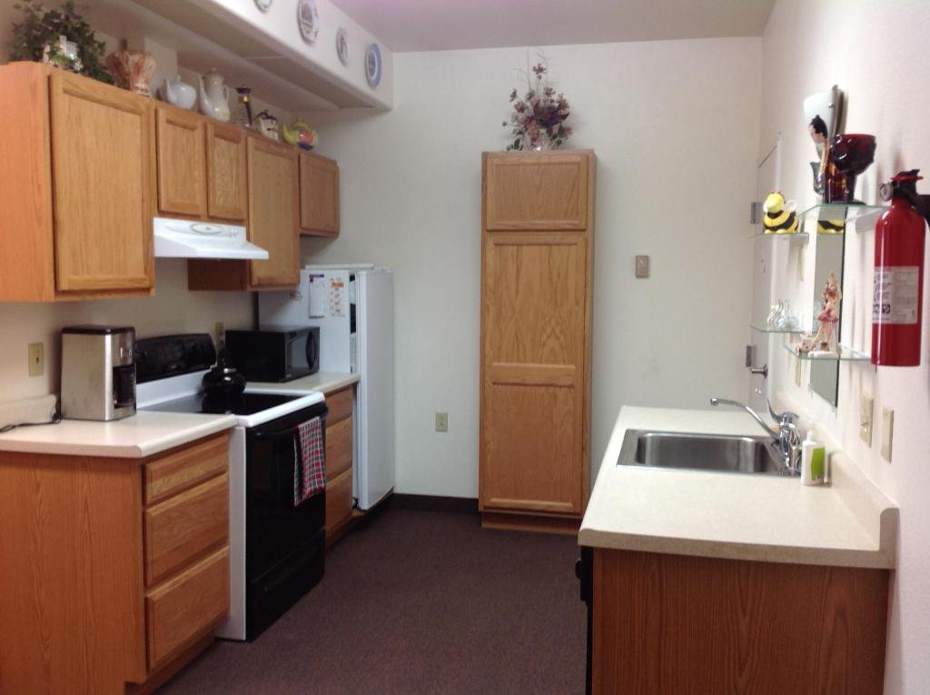 a small kitchen with a sink and a refrigerator at A Suite Alaskan Inn in Fairbanks