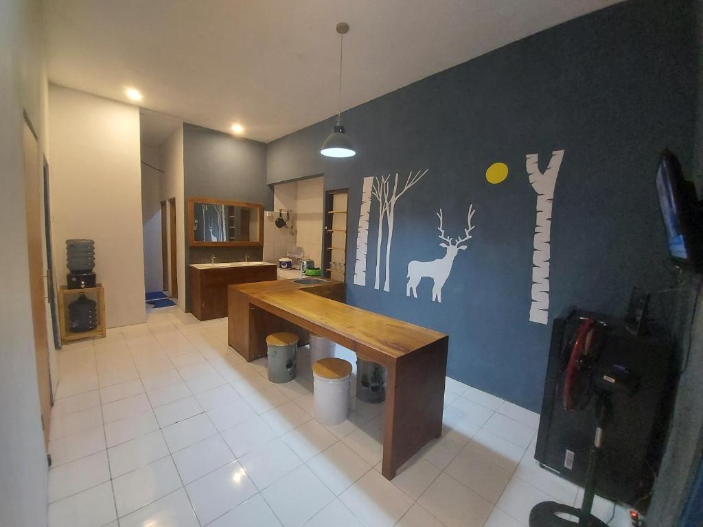 a room with a kitchen with a deer on the wall at FHStay Malioboro in Timuran