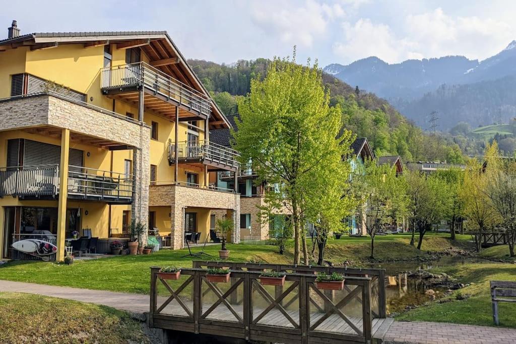 a yellow building with a bridge in front of it at Wonderful holiday home on the shore of Walensee in Quarten