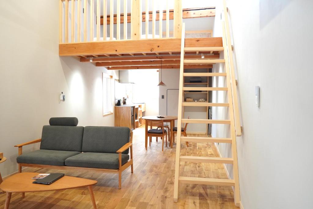 a living room with a loft bed and a couch at Rikka Fukiya in Takayama