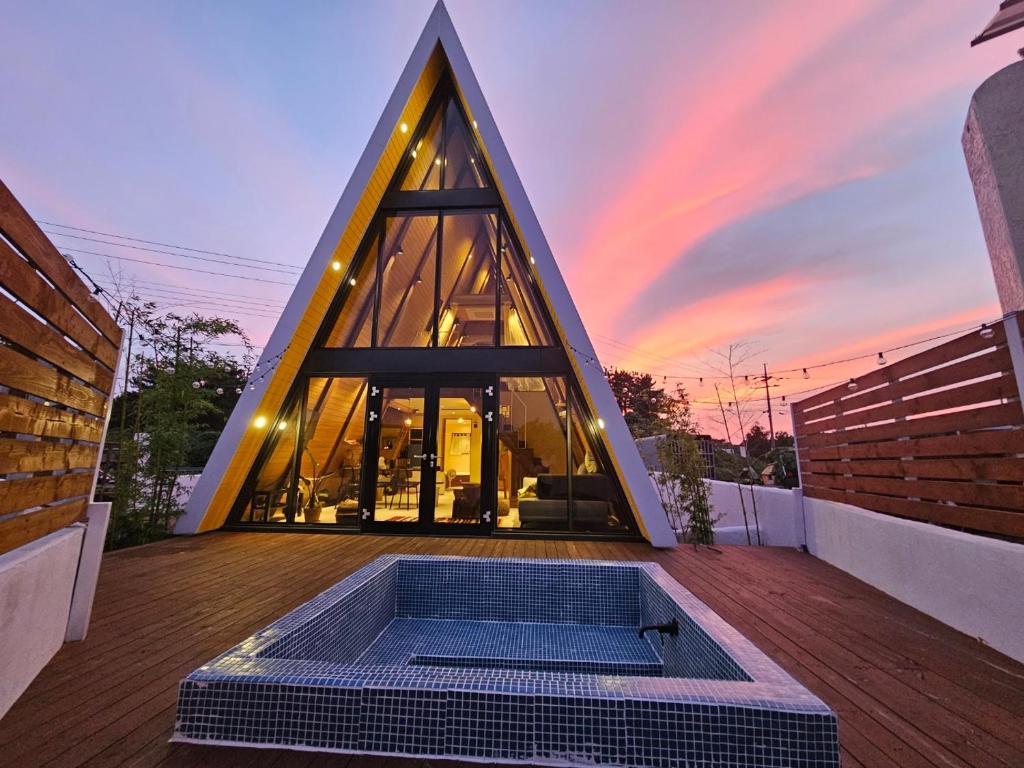 un edificio pirámide con una bañera de hidromasaje en una terraza en Dongbok Sanjang Jeju, en Jeju