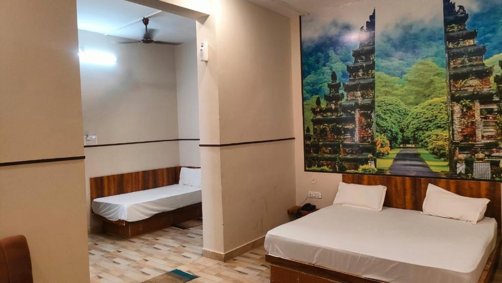 una camera con due letti e un dipinto sul muro di Hotel High Society a Kota
