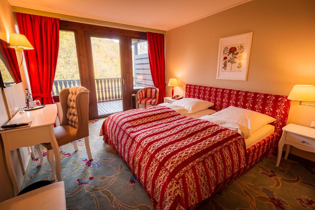um quarto de hotel com uma cama, uma secretária e uma janela em Hotel-Restaurant Burg Hornberg em Neckarzimmern