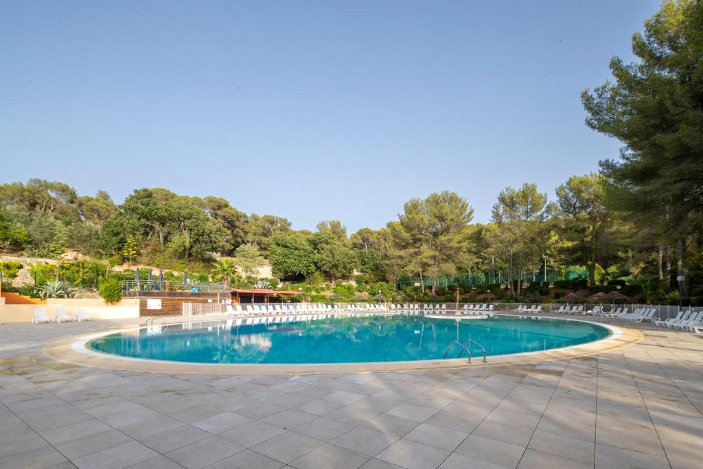 a large swimming pool with chairs around it at Village Vacances Passion La Bayette in Le Pradet
