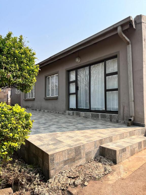 a house with a stone patio in front of it at Sherotha Accommodation in Louis Trichardt