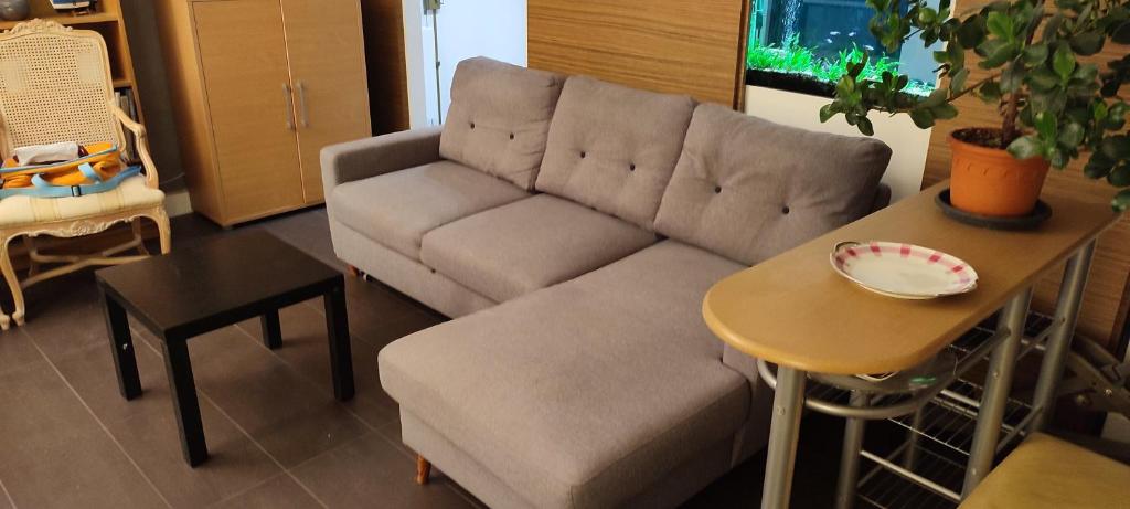 a living room with a couch and a table at Full apt - Top floor - Eiffel Tower Panoramic View in Issy-les-Moulineaux