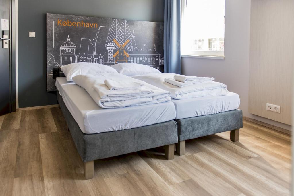 een paar bedden in een kamer met houten vloeren bij a&o Copenhagen Nørrebro in Kopenhagen