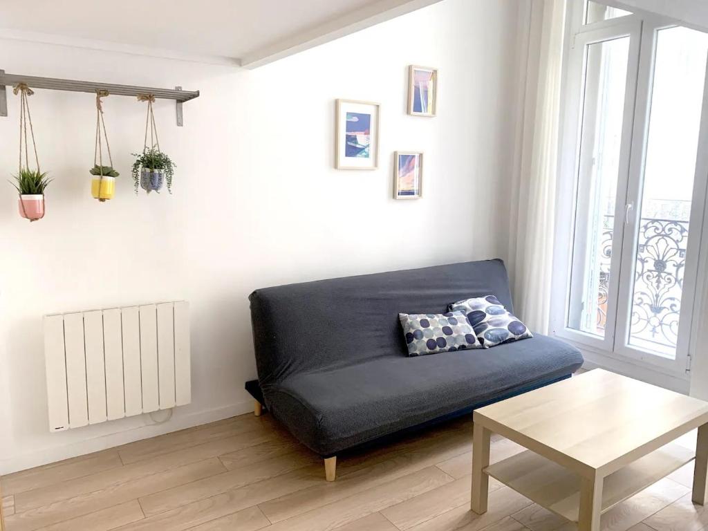 un salon avec un canapé bleu et une table dans l'établissement Sur Rbnb - Heros, à Marseille