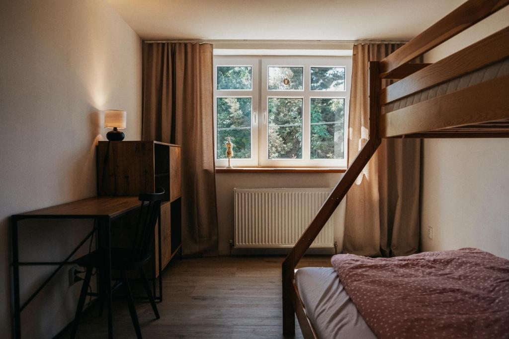 a bedroom with a bunk bed and a desk and a window at Mezi vrchy in Jablonné v Podještědí