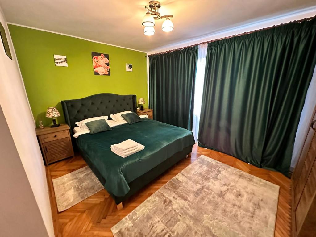 a bedroom with a green bed and a window at Stella's cozy home in Baloteşti