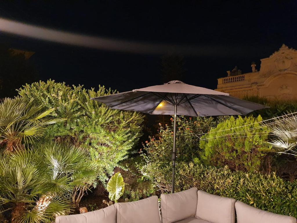 a black umbrella sitting on top of a couch at Mont Boron Exclusive Apartment in Villa Belle Époque in Nice