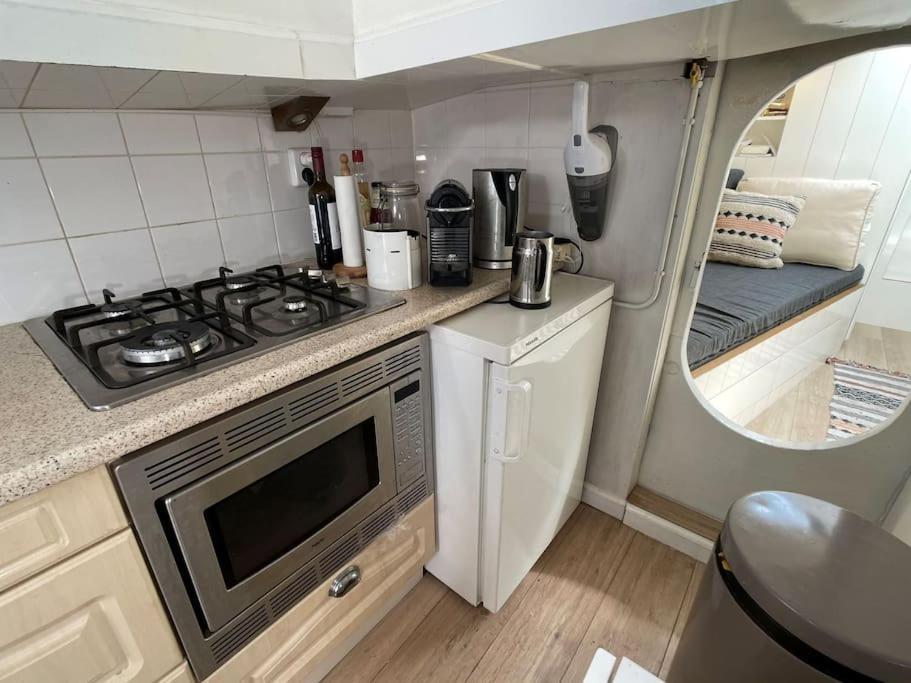a kitchen with a stove and a sink in a caravan at Spacious homely house boat in Amsterdam