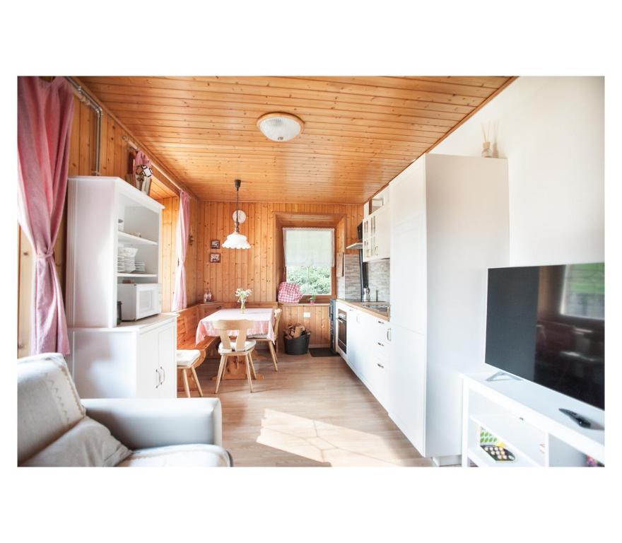 a kitchen with white cabinets and a living room at Apartment Toni in Sarntal