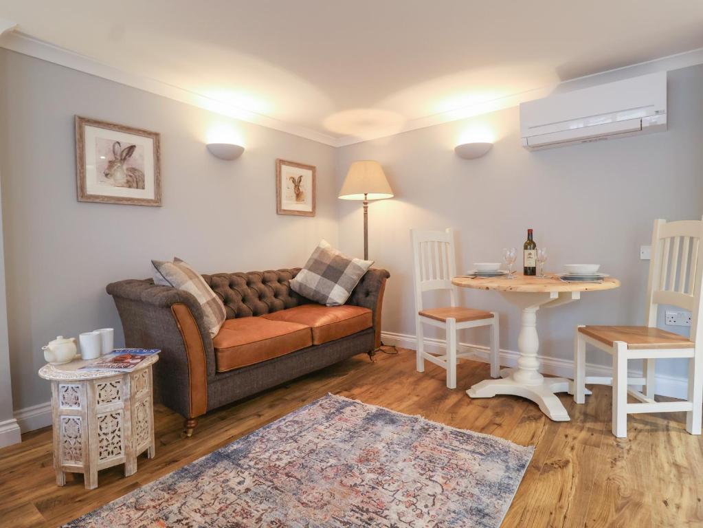 a living room with a couch and a table at Holly House Studio in Sudbury