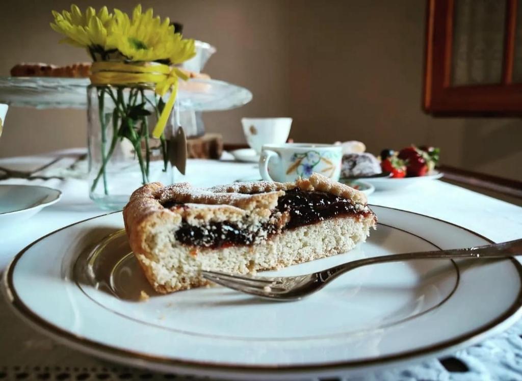 un trozo de pastel de arándanos en un plato con un tenedor en La Casetta di Nerina - Agripark, en Cansano