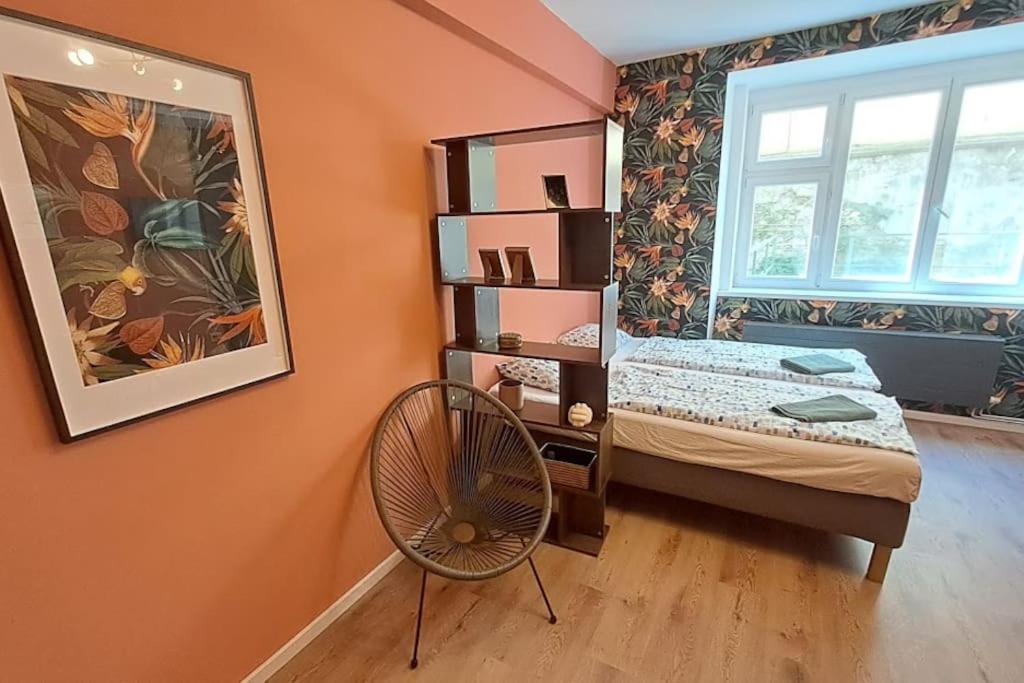 een slaapkamer met een bed, een ventilator en een raam bij Fun bright studio with flat screen TV in Praag