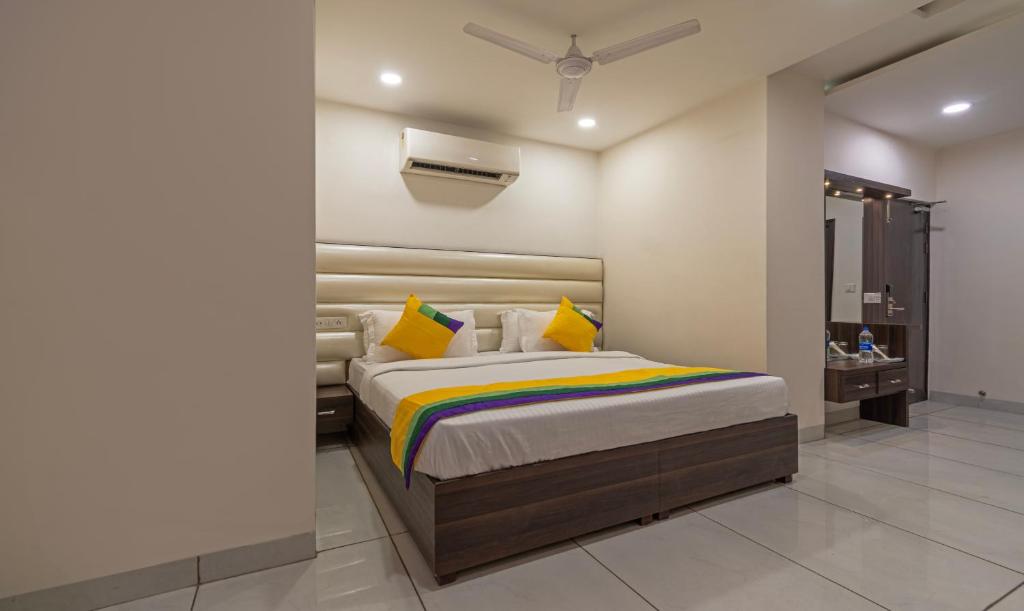 a bedroom with a large bed with yellow pillows at Itsy By Treebo - P Grand in Ludhiana