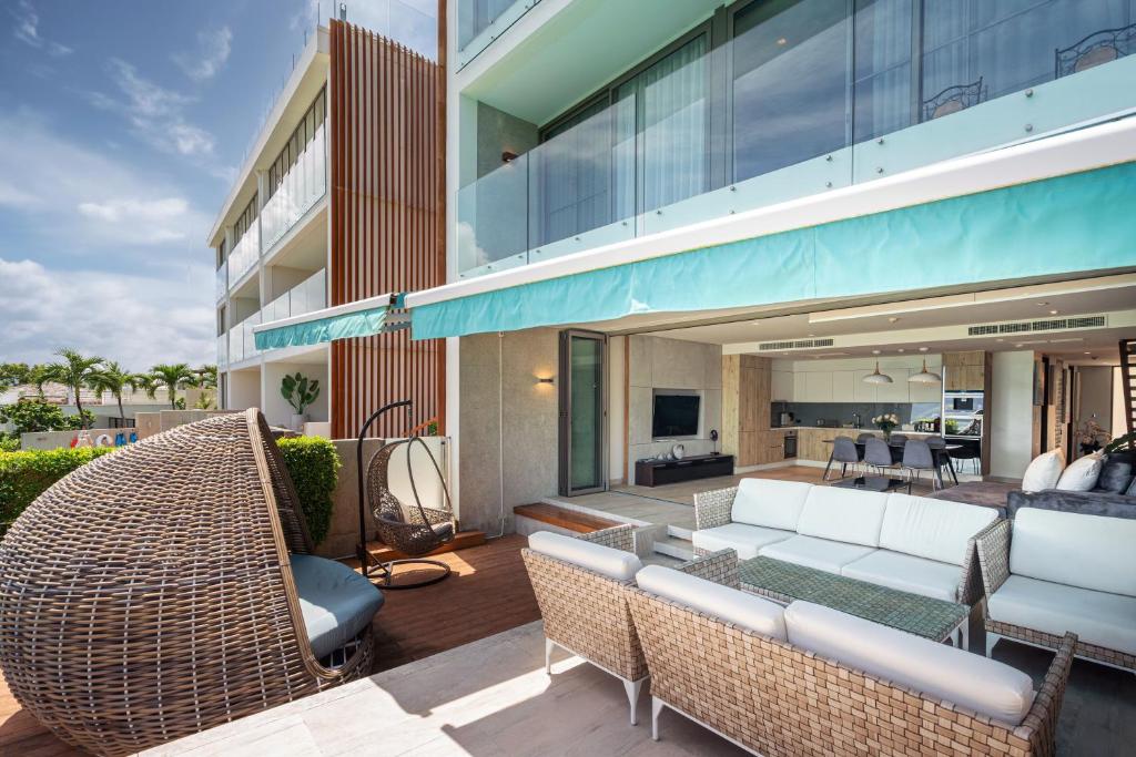 an outdoor patio with wicker furniture and a building at Sea View Duplex per 5 in The Blue Point 88 Residence near Patong and Paradise Beach in Patong Beach