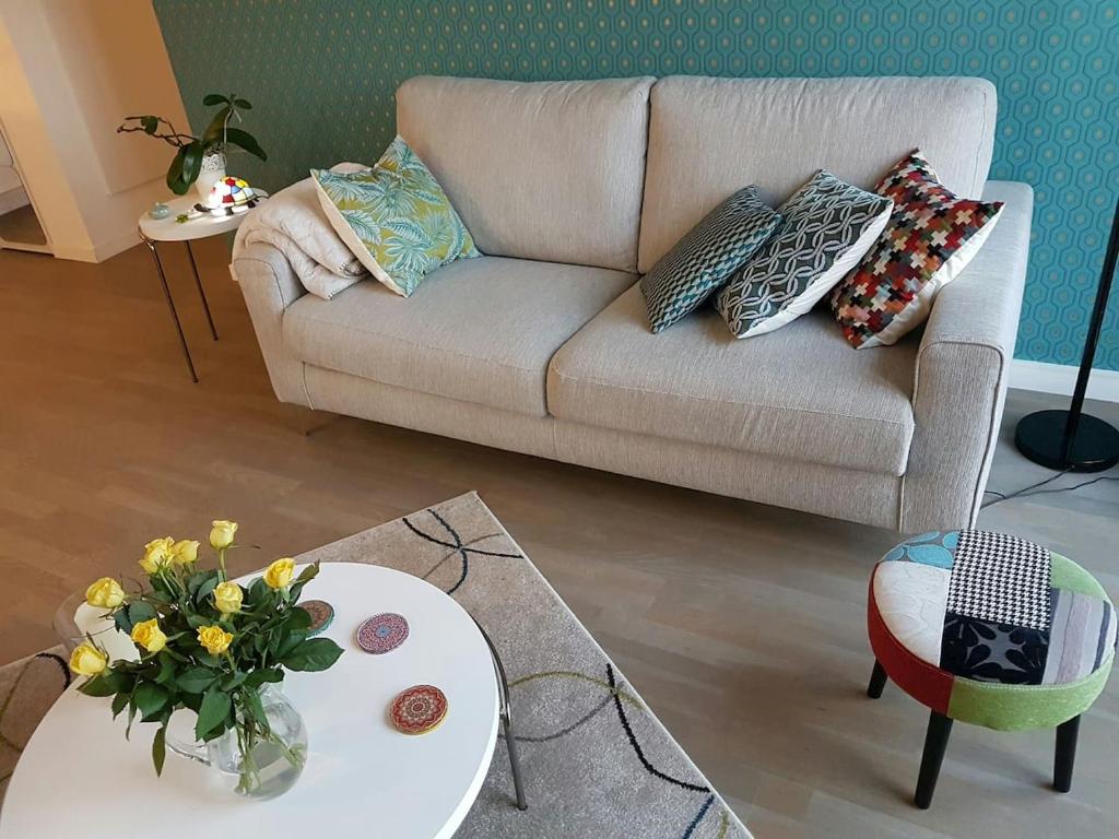 - un salon avec un canapé et une table fleurie dans l'établissement Cosy Bordeaux, à Bordeaux