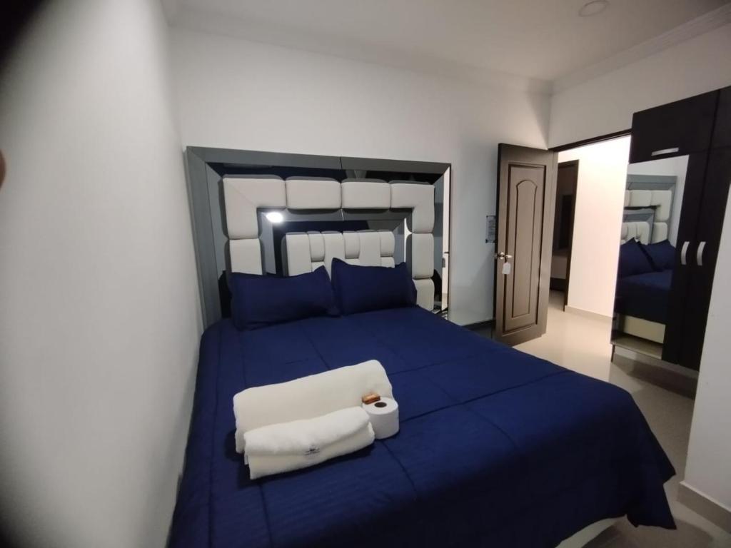 内科克利Hotel Costa Norte的一间卧室配有蓝色的床和2条毛巾