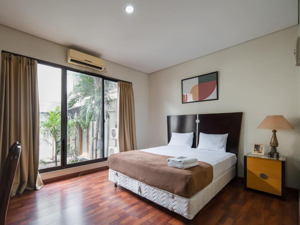 1 dormitorio con cama y ventana grande en Cove Arimbi en Yakarta