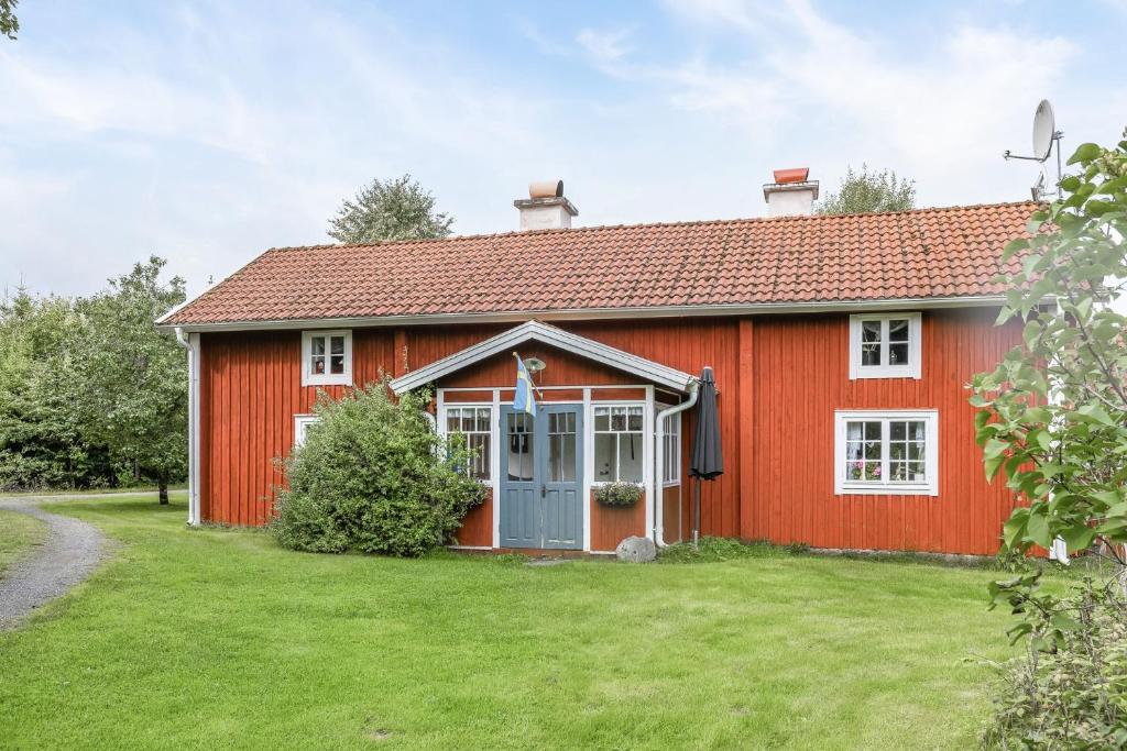 una casa roja con un patio verde en Nice cottage in Bolmstad outside Ljungby, en Ljungby