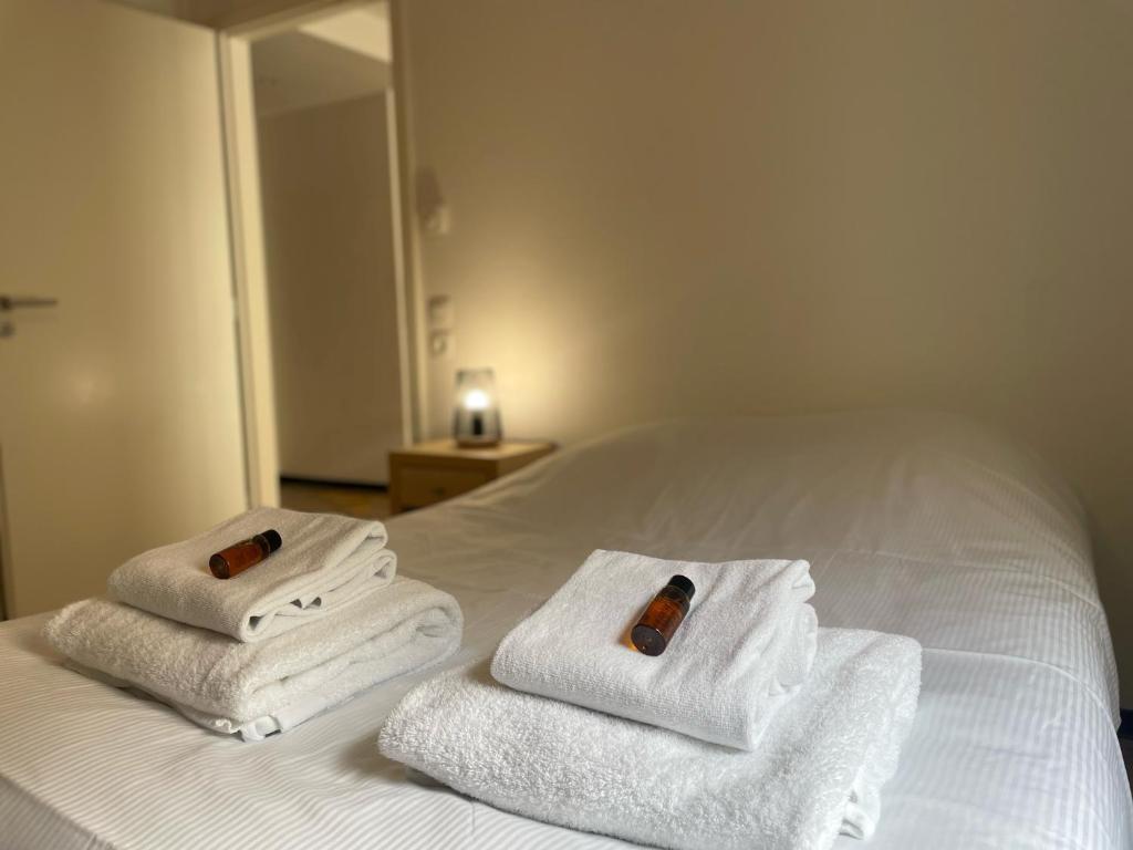 una pila de toallas sentadas encima de una cama en KOSY Appart'Hôtel 7ème Art, en Saint-Avold