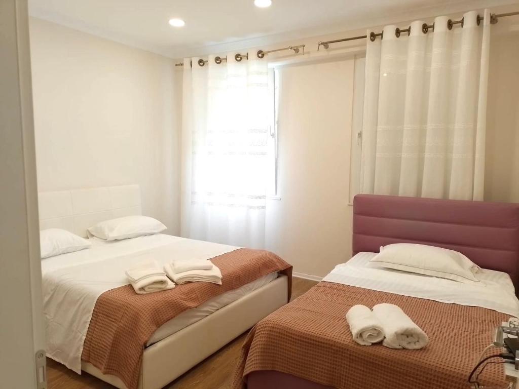 ein Schlafzimmer mit zwei Betten mit Handtüchern darauf in der Unterkunft Serendipity Apartment in Tirana