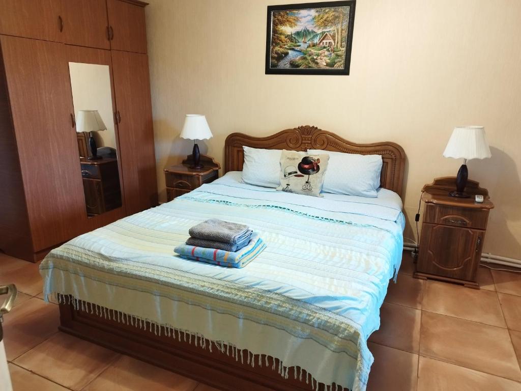 1 dormitorio con 1 cama con 2 mesitas de noche y 2 lámparas en Country House Uliana, en Tskaltubo