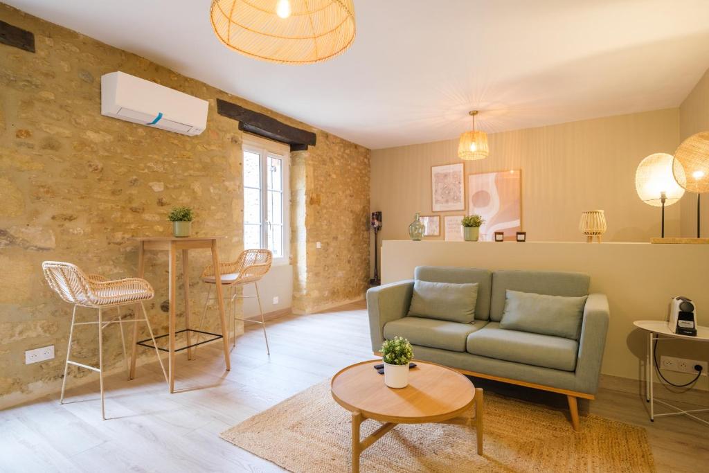 a living room with a couch and a table at La Rousserolle de Sarlat in Sarlat-la-Canéda