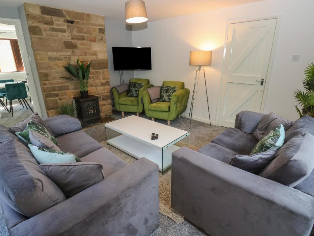 uma sala de estar com dois sofás e uma mesa em Cheshire House em Castleton