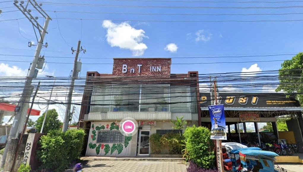 a building with a sign on top of it at BnT Inn in Mactan