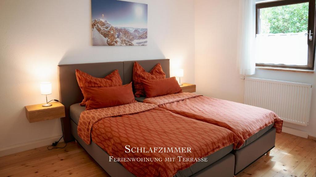 1 dormitorio con 1 cama con almohadas de color naranja en Montana - Ferienwohnung am Laber en Oberammergau