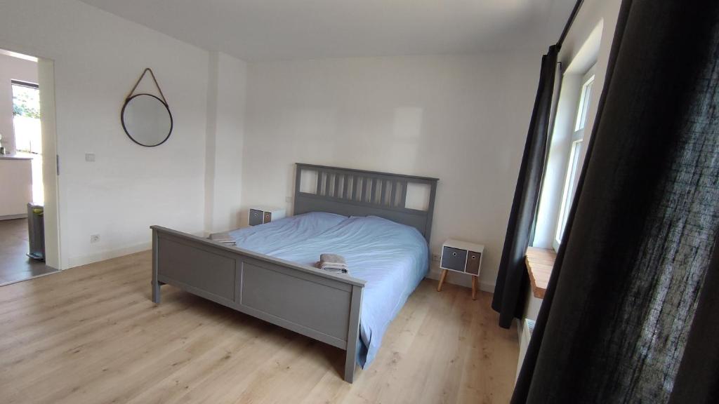 een slaapkamer met een bed en een houten vloer bij Kahnschifferhaus Mönkebude in Mönkebude