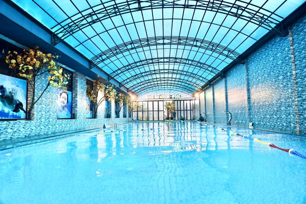 an indoor swimming pool with a glass ceiling at Bình An Nhiên hotel in Ninh Binh