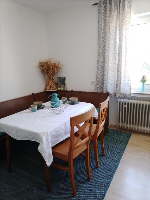 a dining room table with a white table cloth and chairs at Ferienwohnung Elisa in Staig